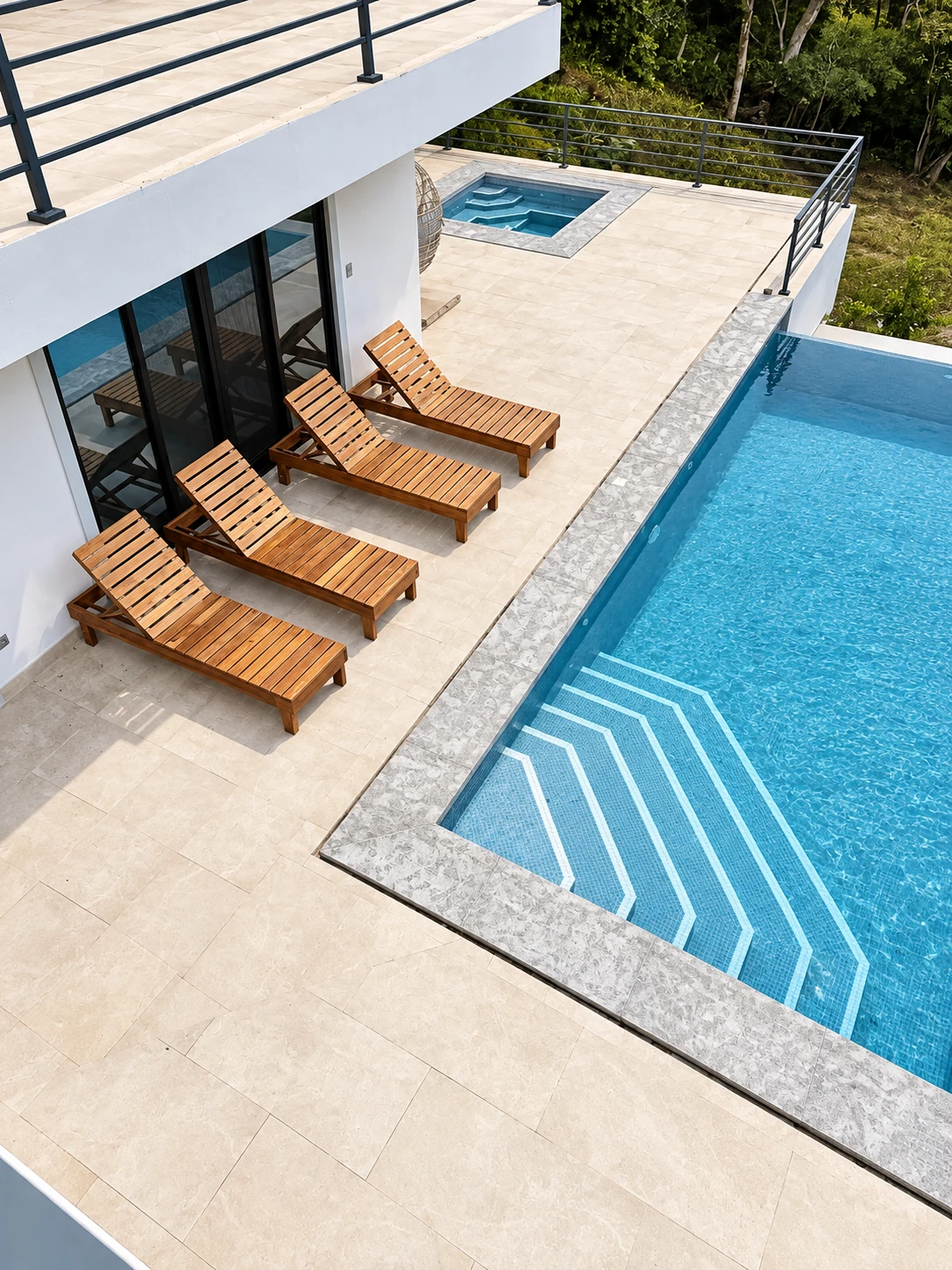 Cuatro asoleadoras de teca con respaldo elevado junto a una piscina
