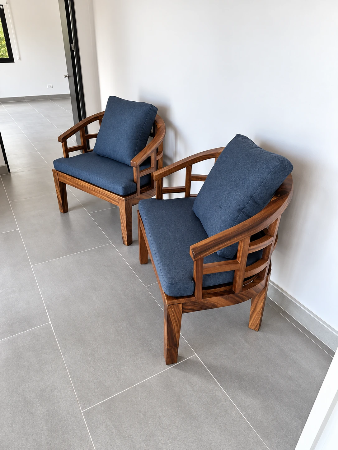 Dos butacas con estructura de madera y cojines azules