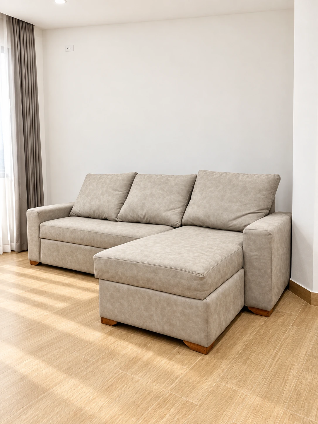 Sofá claro con chaise longue y tres cojines de respaldo